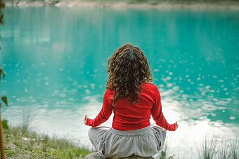 Woman meditating outside in an effort to improve mental health